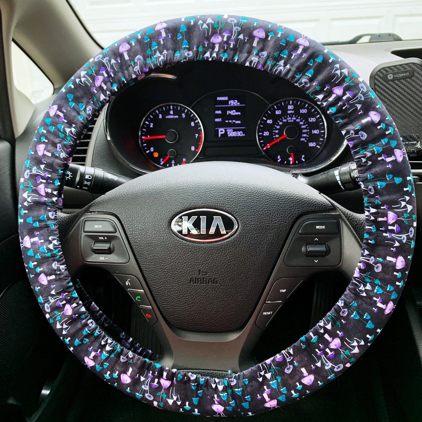 Steering wheel cover with colorful tiny mushroom pattern on a Kia car steering wheel