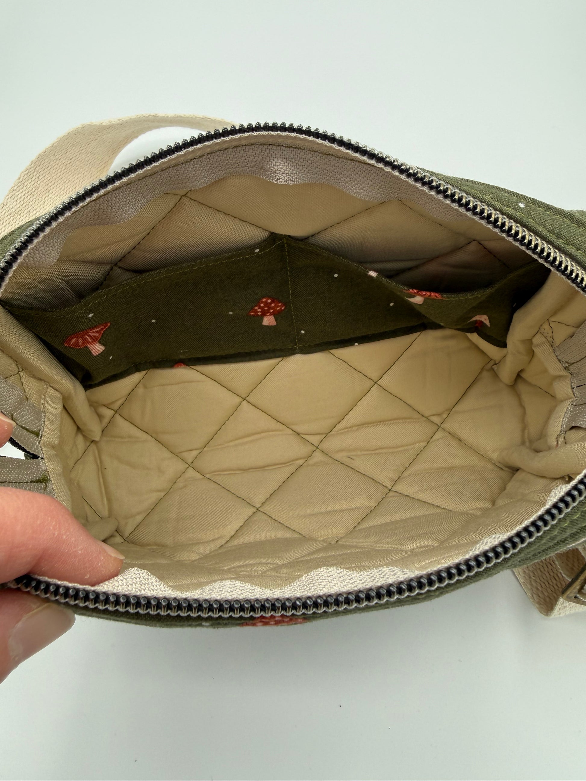 Open beige bag with quilted interior and 2 pockets on a white background