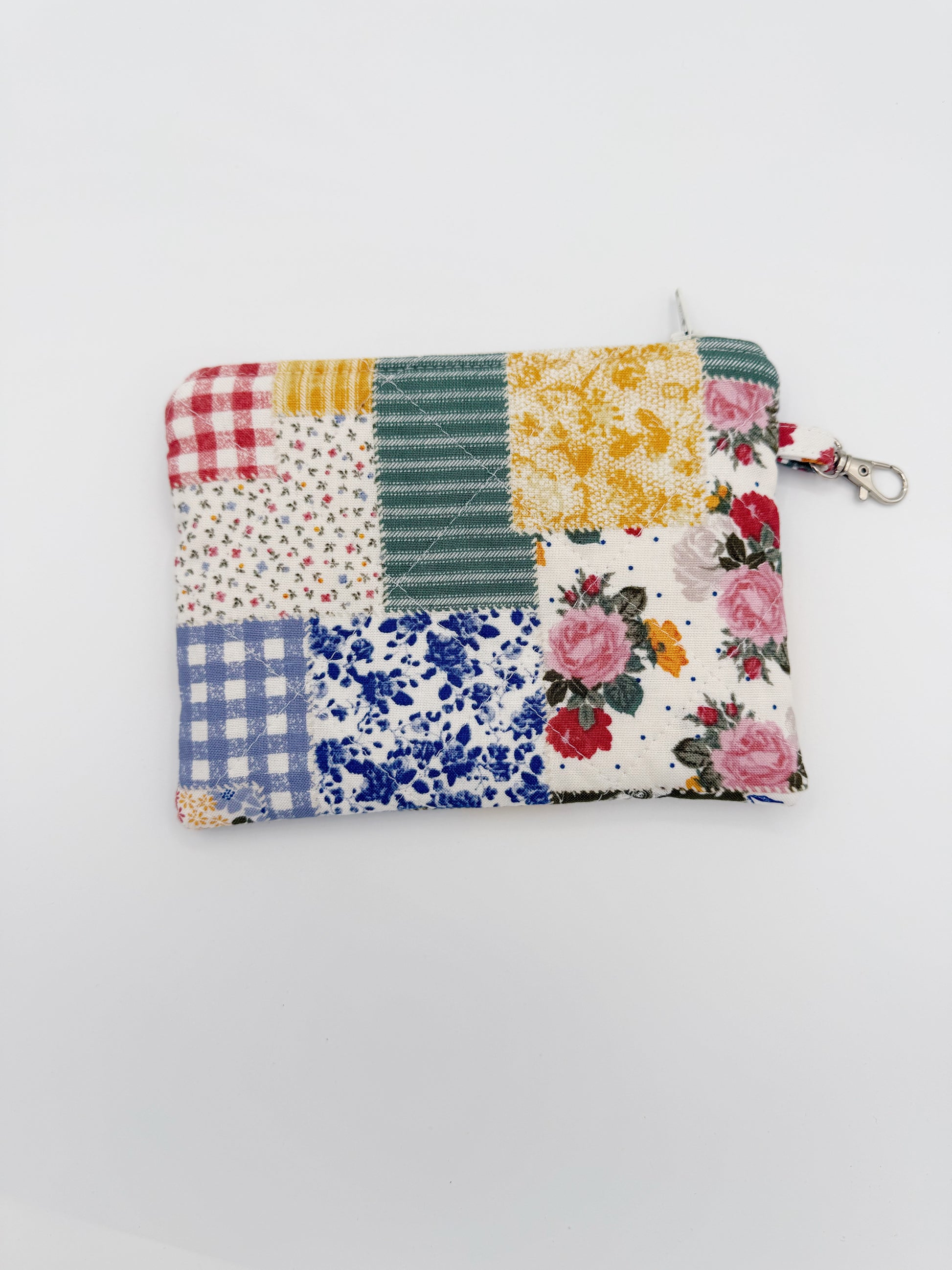 Patchwork pouch with floral and plaid patterns on a white background