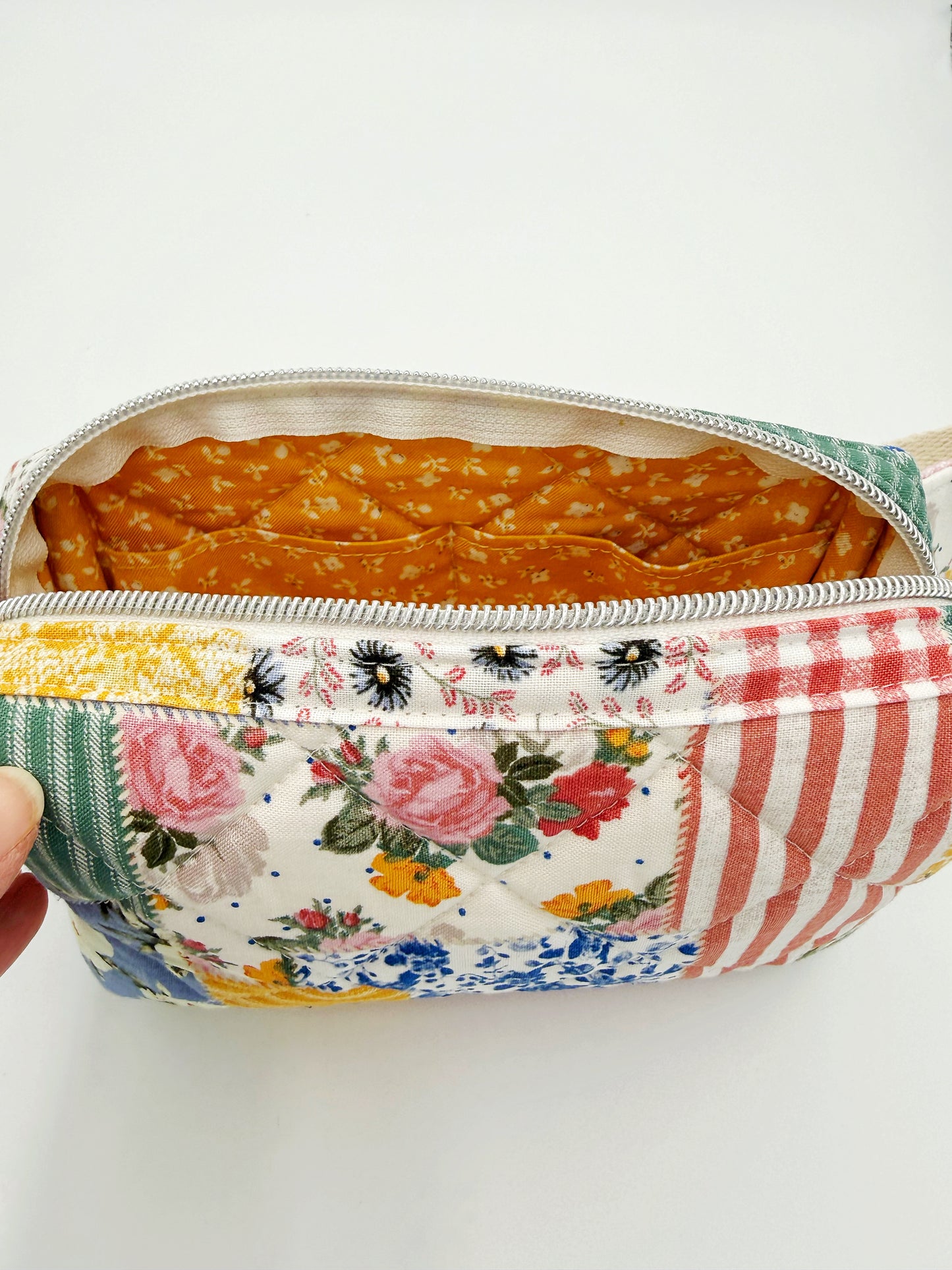 Patchwork belt bag showing inside of bag with zipper view and 2 pockets inside