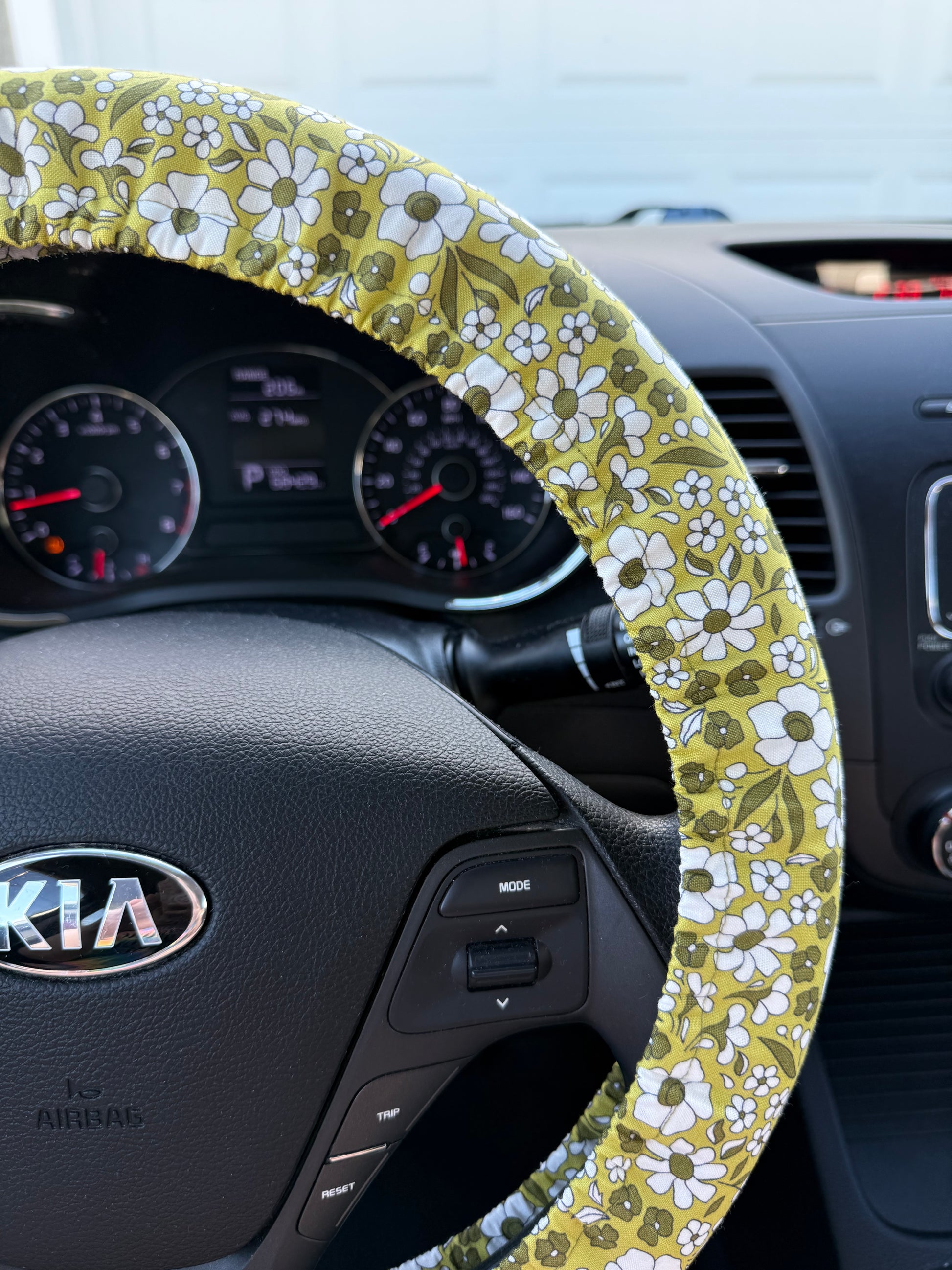 Steering wheel cover with floral pattern on a Kia steering wheel right side view