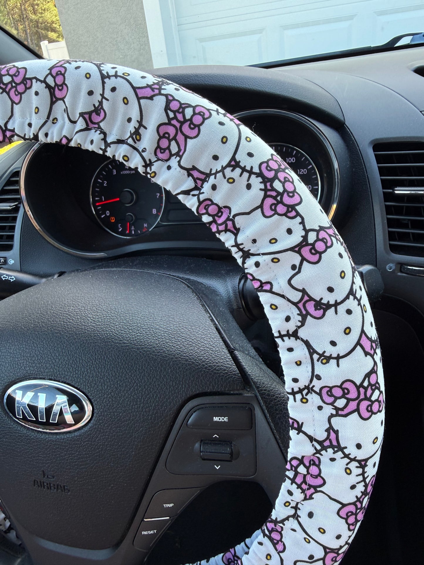 Steering wheel cover with Hello Kitty pattern on a car steering wheel