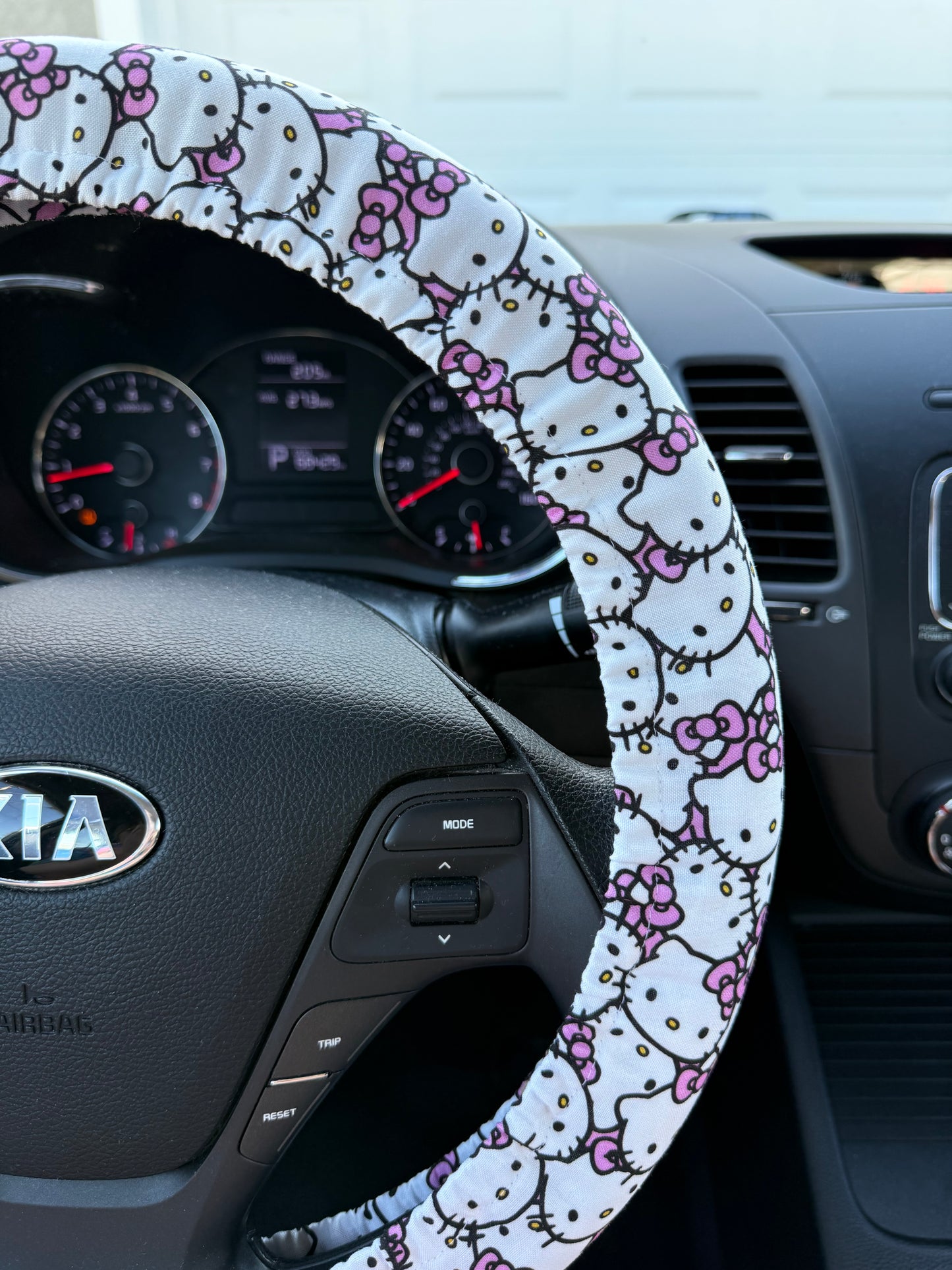 Steering wheel with a Hello Kitty pattern cover inside a car right side view
